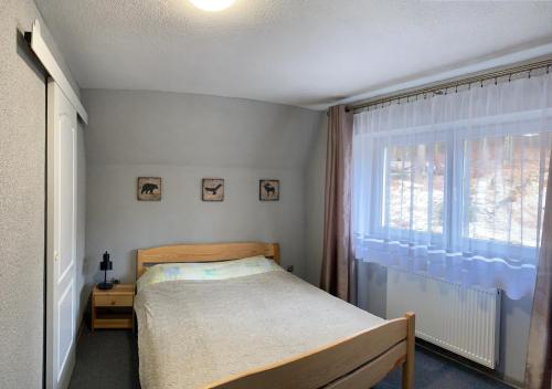 NOC W GÓRACH في كارباش: غرفة نوم صغيرة بها سرير ونافذة