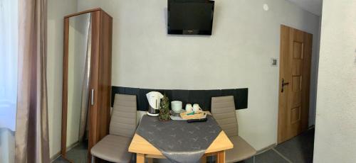 NOC W GÓRACH في كارباش: طاولة صغيرة وكراسي في غرفة بها تلفزيون