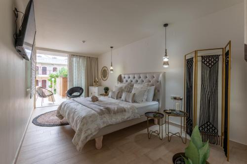 a bedroom with a large bed and a large window at Stelios Gardens in Malia
