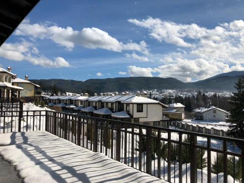 a snow covered balcony with a view of a city at Ruskovets Thermal SPA & Ski Resort in Bansko