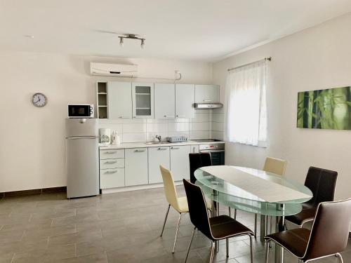 eine Küche mit Tisch und Stühlen und einem Kühlschrank in der Unterkunft Apartments Maric in Vodice