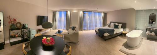sala de estar amplia con cama y sala de estar con sofá en Van der Valk Hotel Sassenheim - Leiden, en Sassenheim