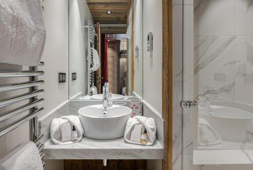 une salle de bain avec un lavabo et une baignoire dans l'établissement Appartement Etoile - LES CHALETS COVAREL, à Val dʼIsère