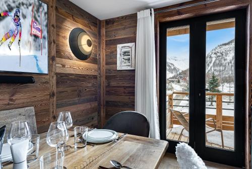 une salle à manger avec une table et une vue sur les montagnes dans l'établissement Appartement Etoile - LES CHALETS COVAREL, à Val dʼIsère