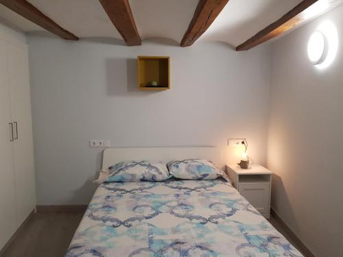 a small bedroom with a bed and a night stand at Ca la Quima in La Seu d'Urgell
