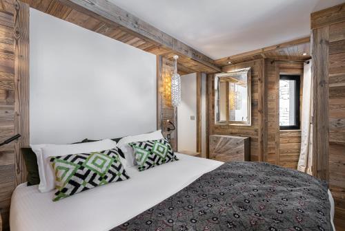 une chambre avec un lit blanc et des murs en bois dans l'établissement Appartement Etoile - LES CHALETS COVAREL, à Val dʼIsère