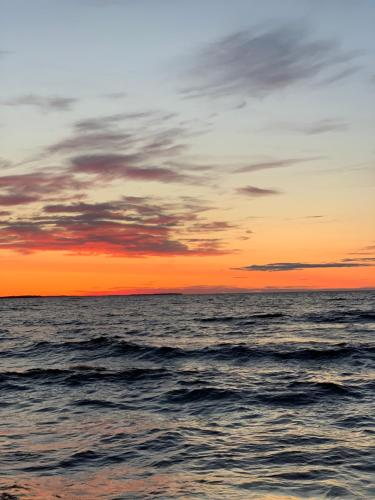 a sunset over the ocean with waves at Les pieds dans le sable in Chambord
