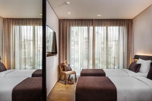 a hotel room with two beds and a window at Imperial Plus Urban Smart Hotel Thessaloniki in Thessaloniki