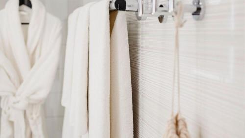 a group of white towels hanging on a rack in a bathroom at Hotel Indigo Madrid - Princesa, an IHG Hotel in Madrid