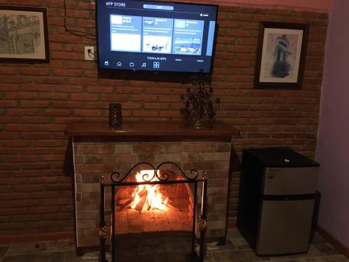 a fireplace with a television and a fire place at Cabaña La Brujita centro del pueblito magico in Mineral del Monte