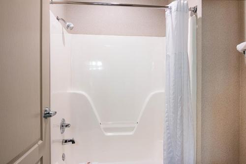 La salle de bains est pourvue d'une douche et d'un rideau de douche blanc. dans l'établissement Comfort Inn Camden, à Camden