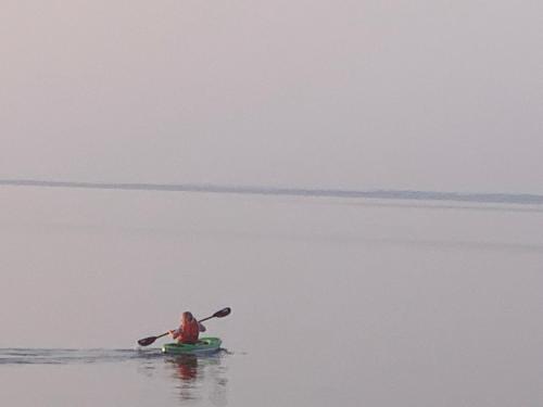 a man in a kayak on a body of water at Les pieds dans le sable in Chambord