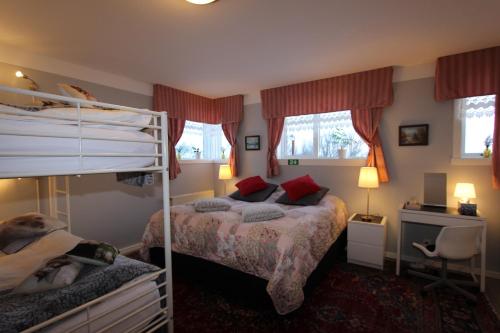 sypialnia z 2 łóżkami piętrowymi i biurkiem w obiekcie The Viking Country Club w mieście Hjalteyri