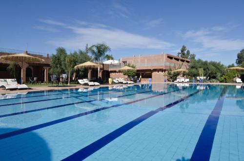 una gran piscina con sillas y sombrillas en Palais Riad Berbère, en Marrakech