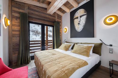 une chambre avec un grand lit et une fenêtre dans l'établissement Penthouse Flèche - LES CHALETS COVAREL, à Val dʼIsère
