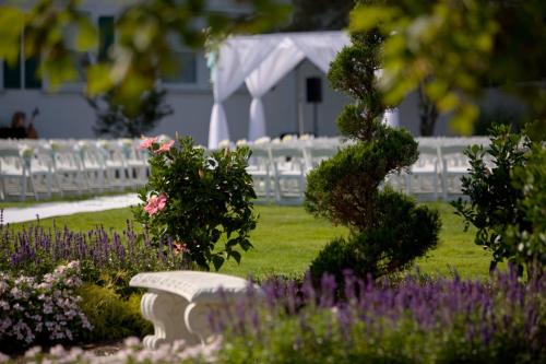 a bench in a garden with flowers and a white fence at Seaview, A Dolce Hotel in Galloway