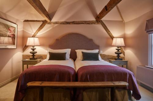 a bedroom with two beds and two lamps at Crown and Anchor in Marlborough