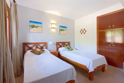 a bedroom with two beds and a cabinet at Apartamentos Colomar in Es Figueral Beach