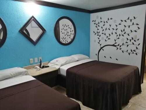 2 camas en una habitación con paredes azules en Privilege, en Coatzacoalcos
