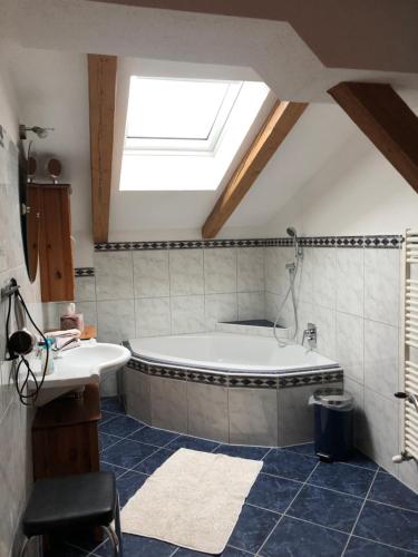 a bathroom with a bath tub and a skylight at Appartement Leirer in Alpbach