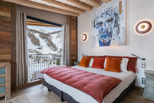 une chambre avec un grand lit et une grande fenêtre dans l'établissement Penthouse Chamois - LES CHALETS COVAREL, à La Daille