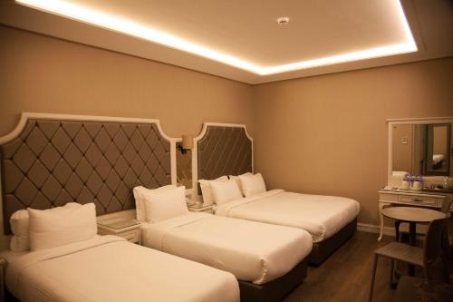 a hotel room with two beds and a mirror at Miss Istanbul Hotel in Istanbul