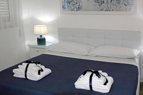 Una cama con toallas encima. en Dimora Grazia in Riva al Mare en Monopoli