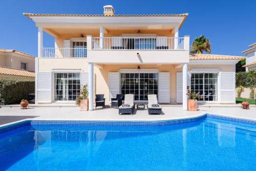 a villa with a swimming pool and a house at Casa Lago in Quinta do Lago