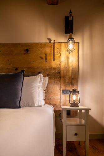 a bedroom with a bed and a table with a clock on it at Borgo Antichi Orti Assisi in Assisi