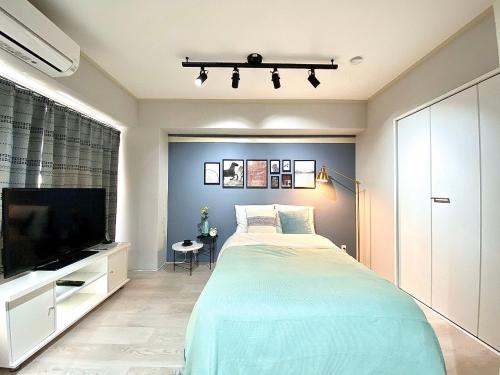a bedroom with a large bed and a flat screen tv at Alo BnB 6 - Near IKEBUKURO, SHINJUKU, UENO, AKIHABARA - Self check-in in Tokyo