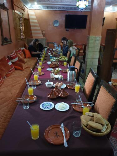 a long table with food and people sitting around it at Chez Ghazal Imlil in Imlil