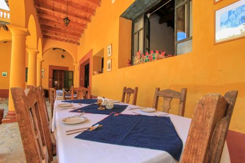 a dining room with a table with a blue napkin at Hotel Na Bolom in San Cristóbal de Las Casas