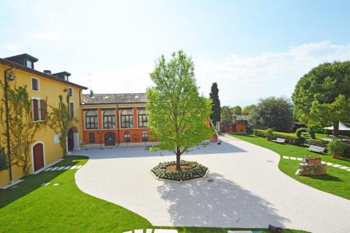 un patio con un árbol en el medio de un edificio en Agriturismo La Filanda, en Manerba del Garda
