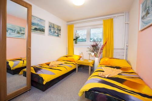 Dos camas en una habitación con espejo. en Guest House Bulušek, en Rokytnice nad Jizerou