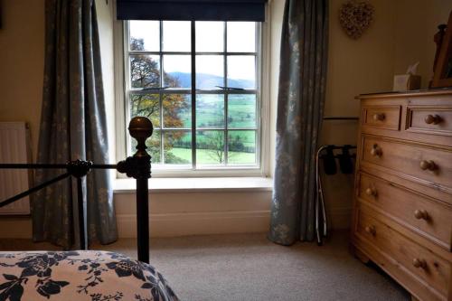 1 dormitorio con ventana, 1 cama y vestidor en Plas yn Yale with mountain views from all windows, en Wrexham