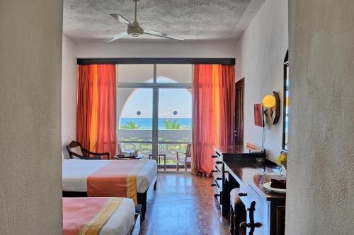 a hotel room with two beds and a view of the ocean at Kaskazi Beach Resort in Diani Beach
