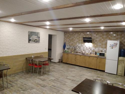 KrymskにあるGuesthouse on Rodnikovaya 9のテーブル付きの部屋、冷蔵庫付きのキッチンが備わる客室です。