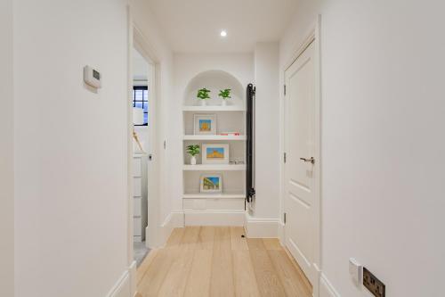 a hallway with white walls and a hard wood floor at Oxfordshire Living - The Churchill Apartment - Woodstock in Woodstock