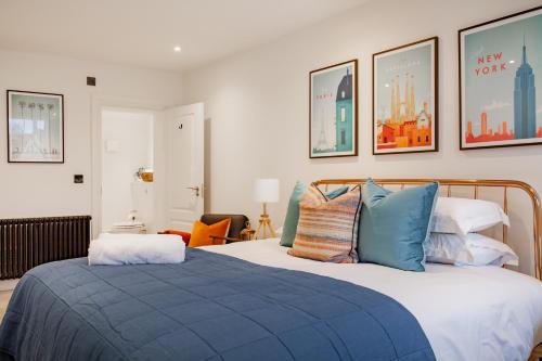 a bedroom with a bed with blue pillows at Oxfordshire Living - The Churchill Apartment - Woodstock in Woodstock