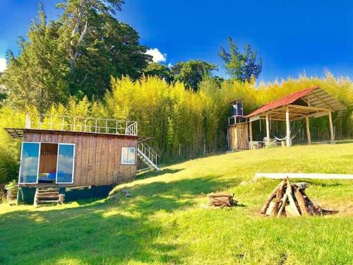 a small cabin in the middle of a grass field at Cabaña Mountain View in Heredia