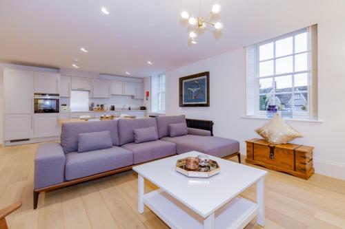 a living room with a purple couch and a table at Oxfordshire Living - The Churchill Apartment - Woodstock in Woodstock