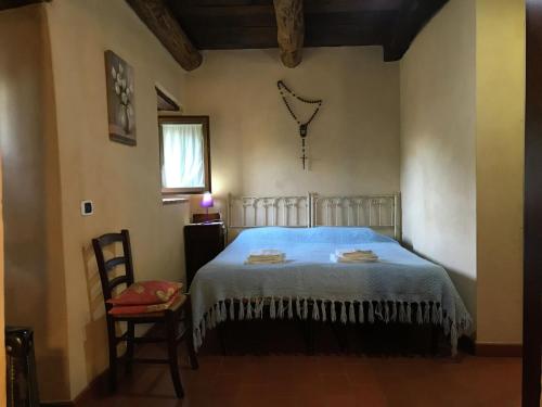 a bedroom with a bed and a chair and a window at Splendid Cottage in Vergemoli with Barbecue and Garden in Fornovolasco