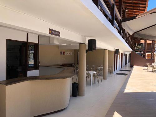 a restaurant with a bar and tables and chairs at Rede Andrade Estrela Dalva Praia Hotel in Porto Seguro