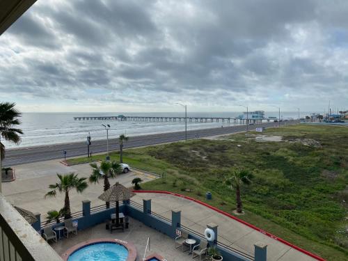 a view of the beach and the ocean with a pier at Galveston Beach Hotel in Galveston