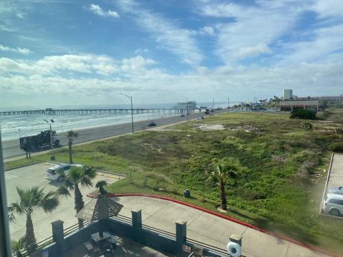 a view of a beach with a pier and the ocean at Galveston Beach Hotel in Galveston