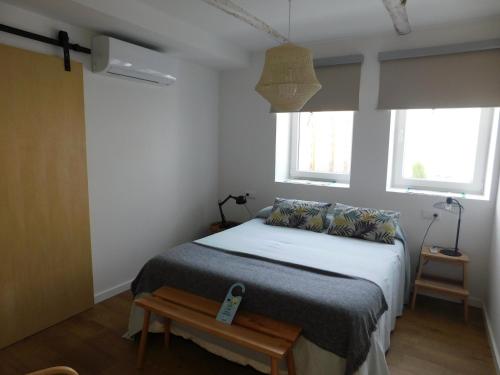 a bedroom with a bed and two windows at La Casita de Melón in Suances