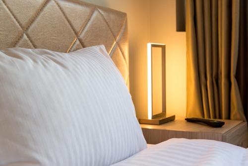 1 cama con almohada blanca y espejo en City Center, en Tesalónica