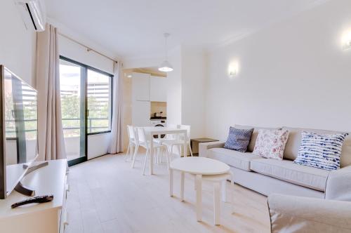 a living room with a couch and a table at Tália - City Center - Vilamoura in Vilamoura