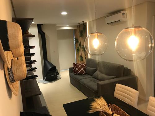 ein Wohnzimmer mit einem Sofa und einem Tisch in der Unterkunft Apartamento Vêneto in Canela