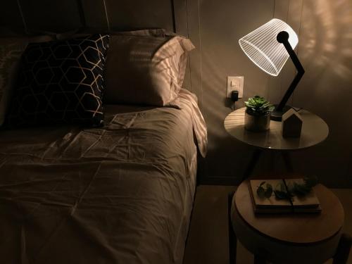 a bedroom with a bed and a table with a lamp at Apartamento Vêneto in Canela